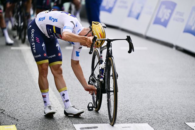 Remco Evenepoel, ciclista belga de 25 anos da Soudal Quick Step, olha para a bicicleta antes da partida para a 14.ª etapa do Tour, precisamente a que ditou o abandono do campeão olímpico de fundo e crono