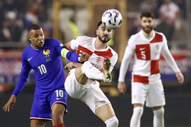 Kylian Mbappé discute a bola com Josip Sutalo