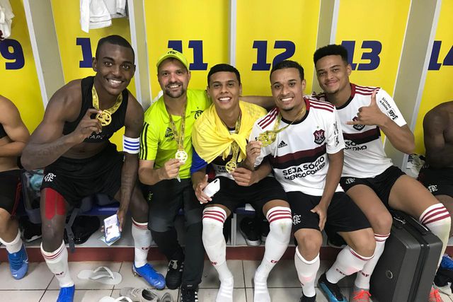 Richard Ríos, ao centro, envolvido pela bandeira colombiana, e ao lado do treinador Maurício Souza, nos sub-20 do Flamengo (D.R.)