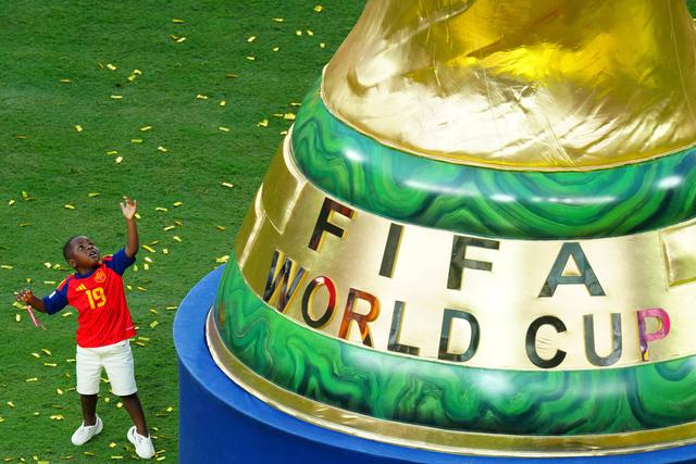 Keyne, irmão de Lamine Yama, junto à reprodução do toféu de campeão do mundo