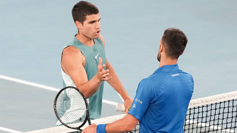 Novak Djokovic e Carlos Alcaraz cumprimentam-se à rede após o duelo nos quartos de final do Open da Austrália