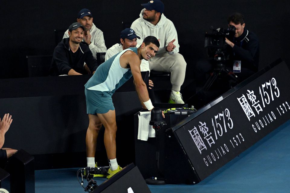 Carlos Alcaraz sorri num momento de pausa no jogo frente a Novak Djokovic, no Open da Austrália