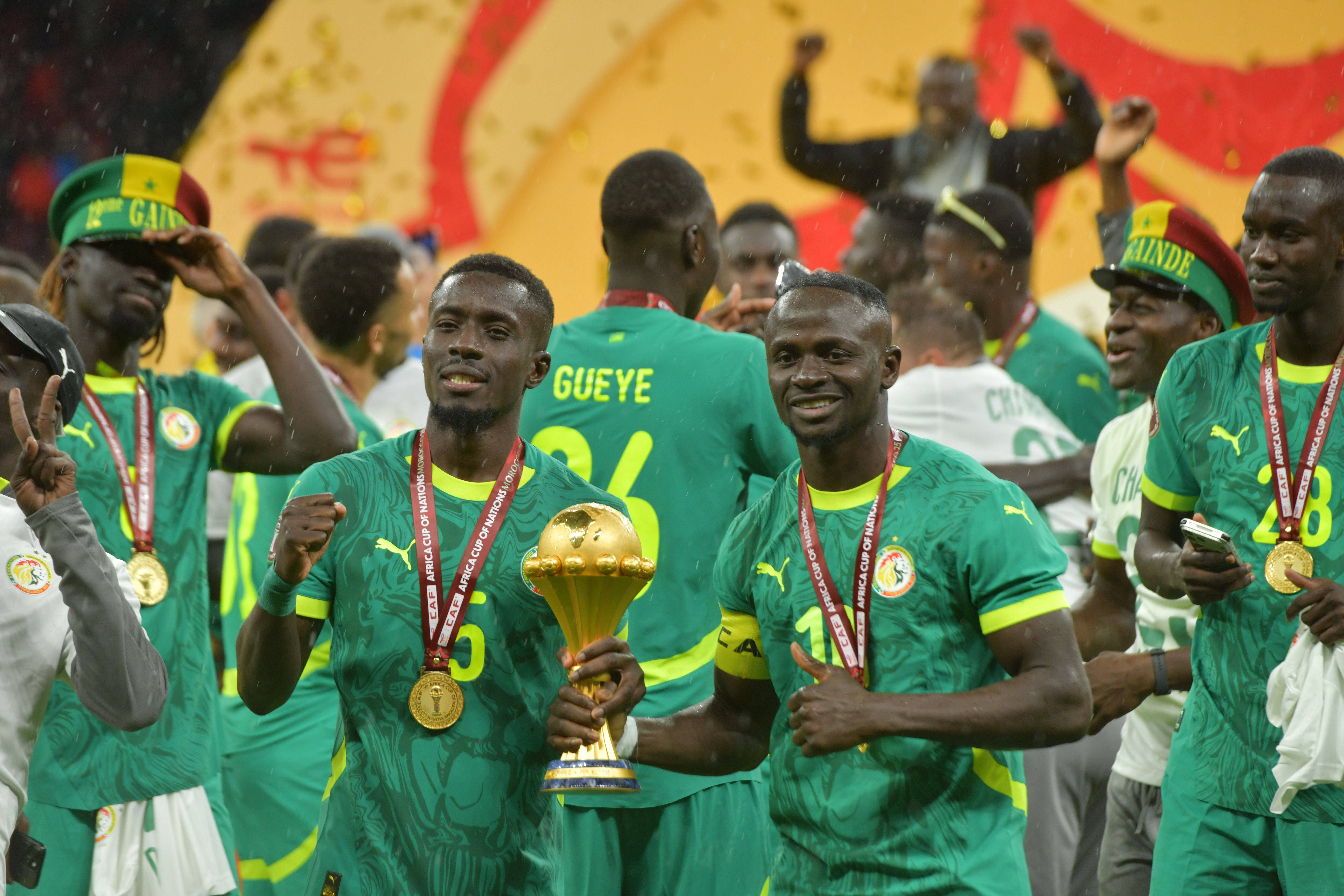 Idrissa Gana Gueye com Sadio Mané a segurar o troféu de campeão africano em 2025