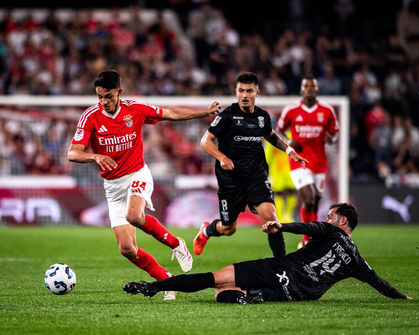 João Rego, do Benfica, tenta passar por Franco, do Tirsense, que em carrinho não consegue travar a marcha do encarnado. Na primeira mão dos quartos de final da Taça de Portugal, os encarnados golearam, por 5-0