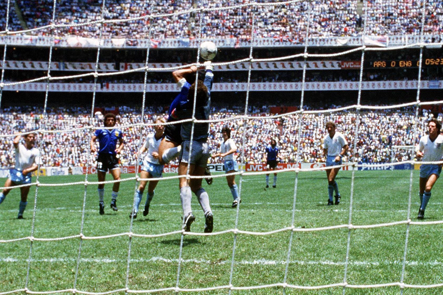 Momento em que Maradona toca a bola com a mão, abrindo o marcador no jogo entre Argentina e Inglaterra, dos quartos de final do Mundial 1986 - Foto: IMAGO