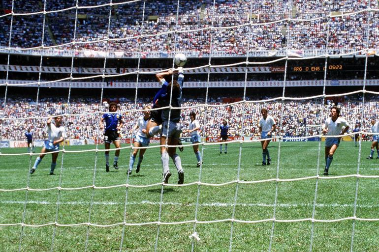 Momento em que Maradona toca a bola com a mão, abrindo o marcador no jogo entre Argentina e Inglaterra, dos quartos de final do Mundial 1986 - Foto: IMAGO