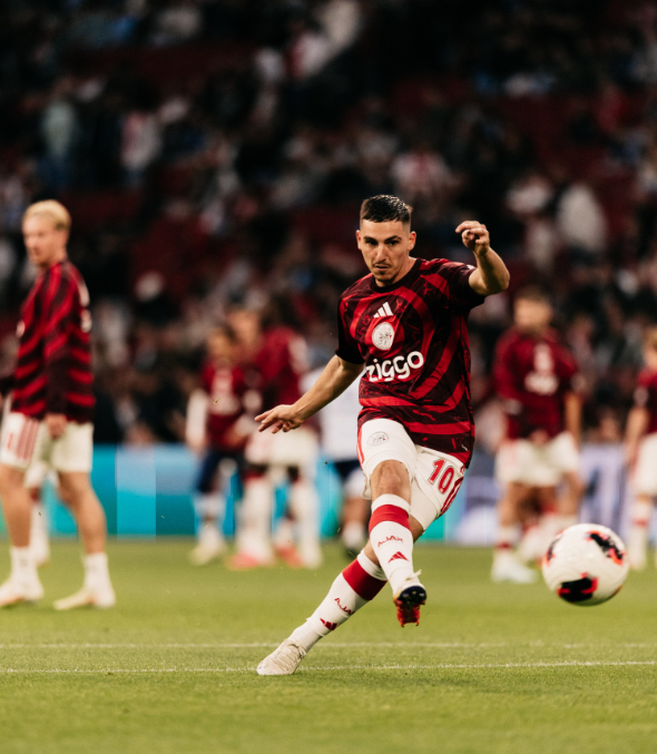 As más: camisola de aquecimento - Ajax/X.  Hipnótico. «Anéis concêntricos a emanar do emblema central, inspirados no telhado do antigo estádio, o De Meer»