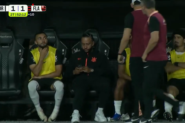 Memphis Depay ao telemóvel antes de ser abordado por dois elementos do staff do Corinthians