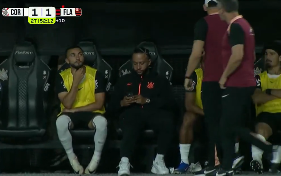 Memphis Depay ao telemóvel antes de ser abordado por dois elementos do staff do Corinthians