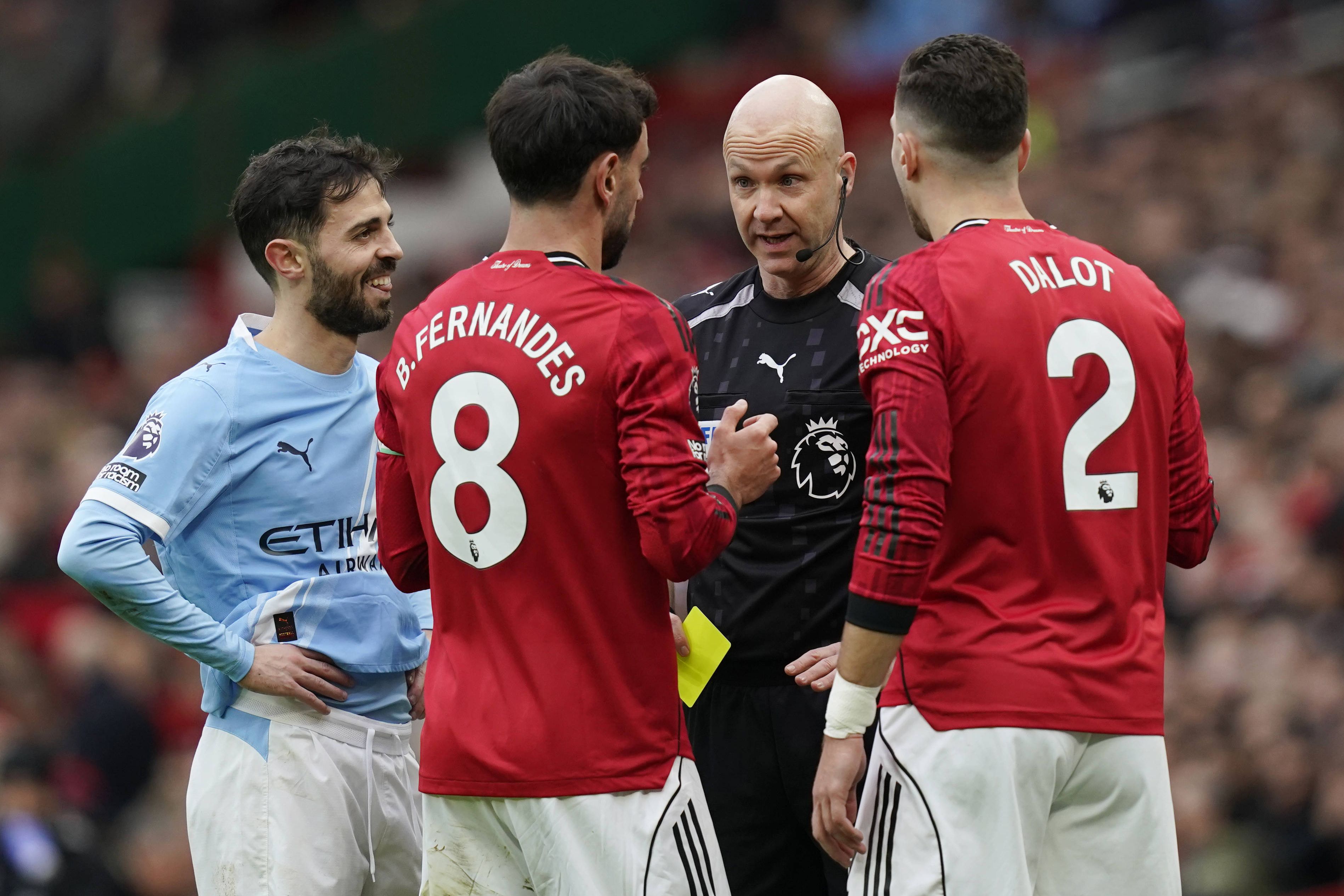 Bernardo Silva sorridente ao lado dos compatriotas Bruno Fernandes e Diogo Dalot no dérbi de Manchester