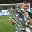 Sorridente, Rui Borges, treinador do Sporting, segura, com ambas as mãos, o troféu alusivo à conquista do título de campeão nacional na temporada de 2024/2025