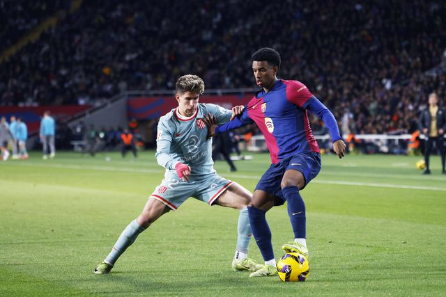 Alejandro Balde, do Barcelona, tem a bola controlada perante a oposição de Giuliano Simeone, do Atl. Madrid. Os dois clubes medem forças nesta terça-feira, 25 de fevereiro, para a Taça do Rei