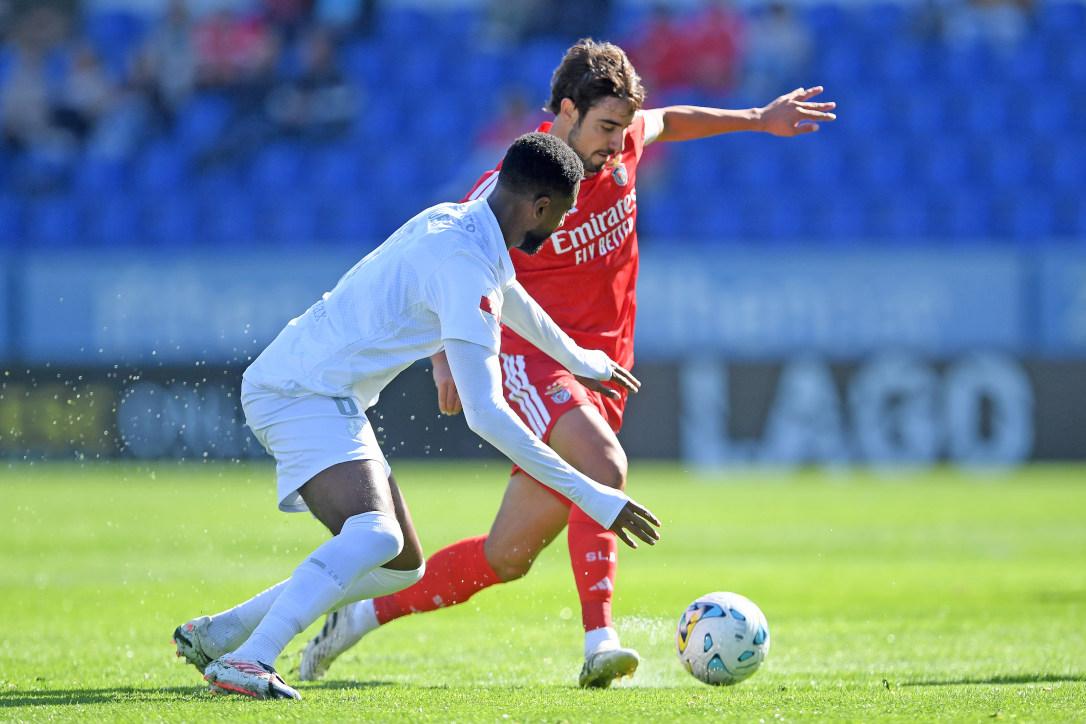 Nuno Félix conduz a bola com oposição de Diogo Mendes — Foto: SL Benfica