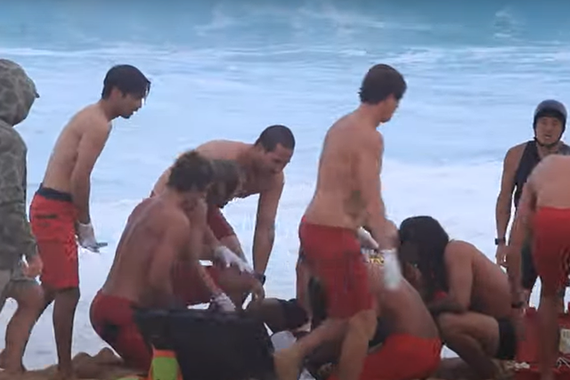 Makai McNamara após ter sido retirado da água por elementos salva-vidas e surfistas