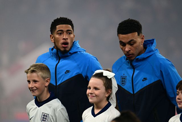 Jude Bellingham e Morgan Rogers lado a lado com as equipas perfiladas antes do Inglaterra-Letónia