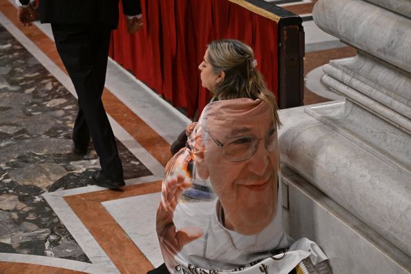 Crente com bandeira do Papa Francisco nas costas, Vaticano, abril de 2025. FOTO IMAGO
