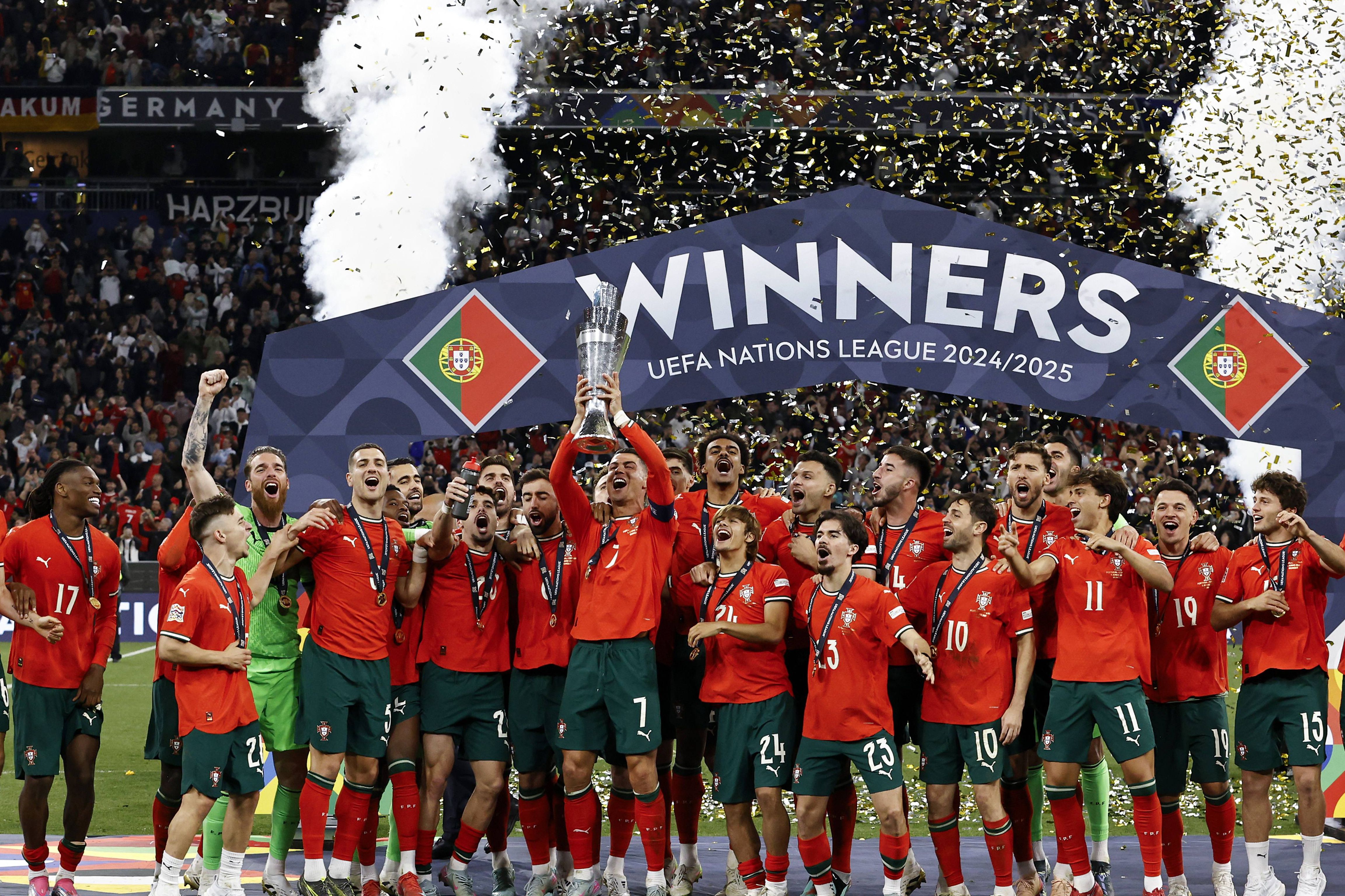 Cristiano Ronaldo, rodeado pelos restantes jogadores da Seleção Nacional, ergue aos céus o troféu correspondente à vitória de Portugal na última edição da Liga das Nações