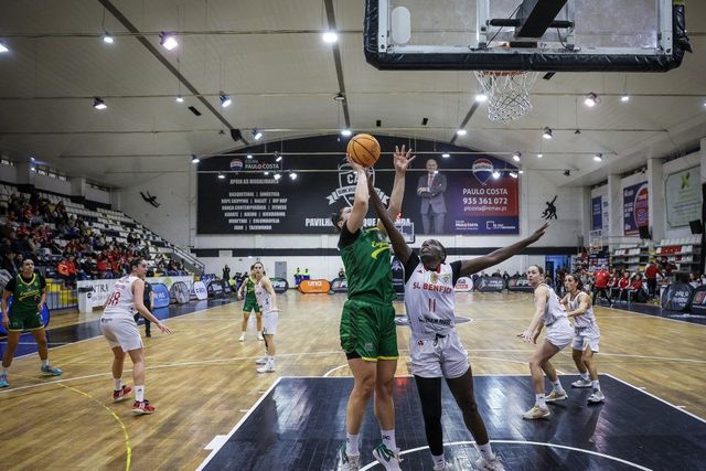 Jogadora do Esgueira lança ao cesto perante a oposição de uma jogadora do Benfica