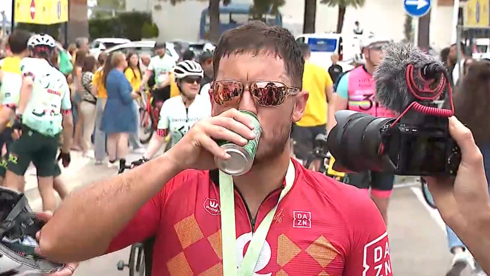 Hazard bebe uma cerveja após uma corrida de ciclismo