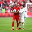 Harry Kane viu o cartão amarelo frente ao Mainz, segurando a bola e fugindo do adversário