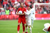 Harry Kane viu o cartão amarelo frente ao Mainz, segurando a bola e fugindo do adversário