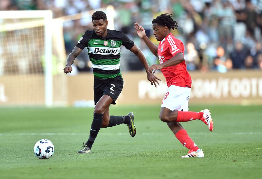 Matheus Reis, defesa do Sporting, conduz a bola perante a oposição de Leandro Barreiro, médio do Benfica