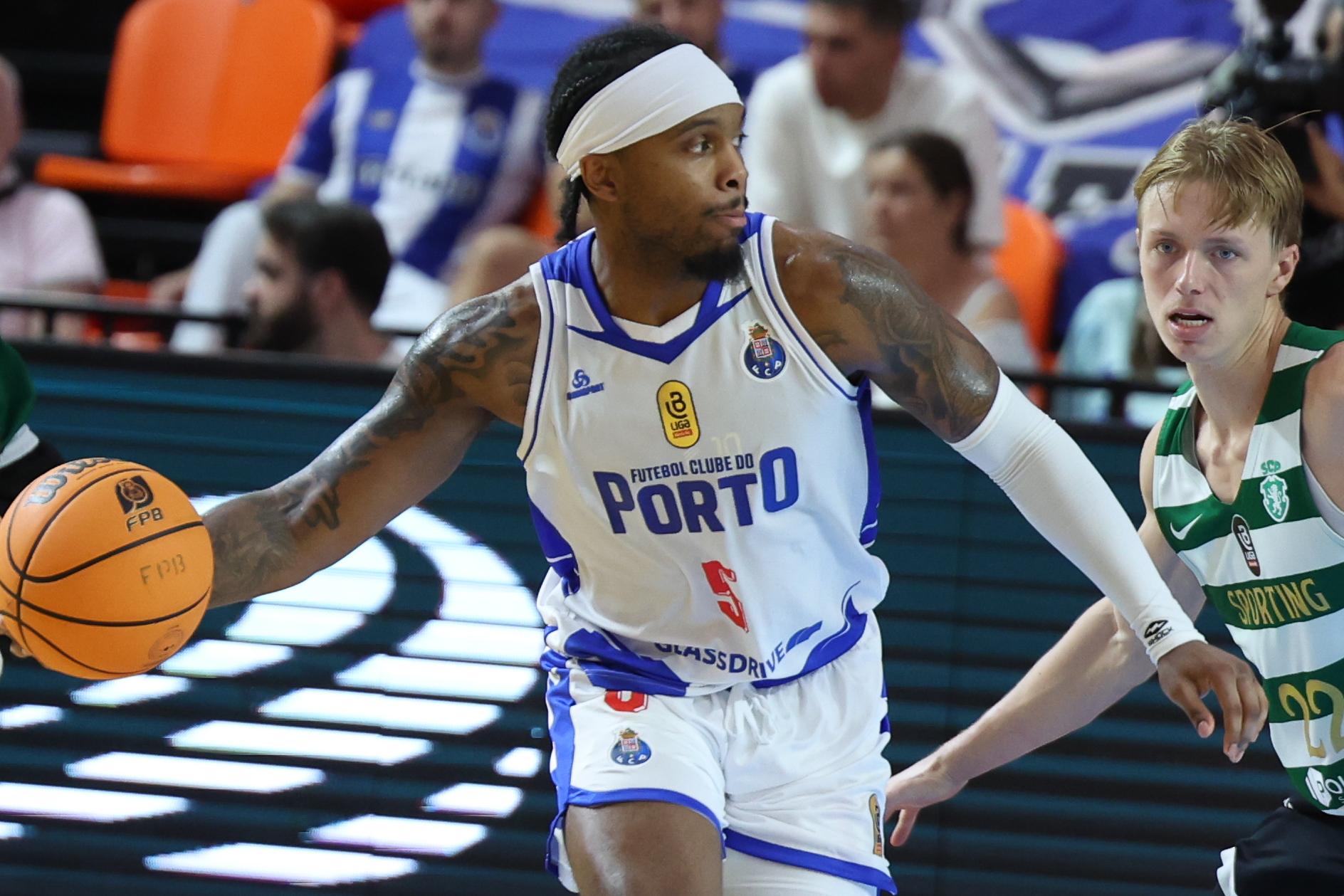 Corei Allen controla a bola perante o olhar de Trevor Baskin, na Supertaça de basquetebol entre o FC Porto e o Sporting - Foto: LUIS FORRA/LUSA