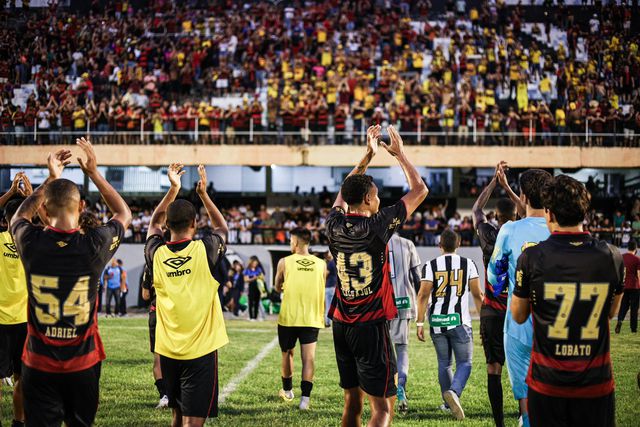 Jogadores aplaudem na direção das bancadas, agradecendo apoio dos adeptos