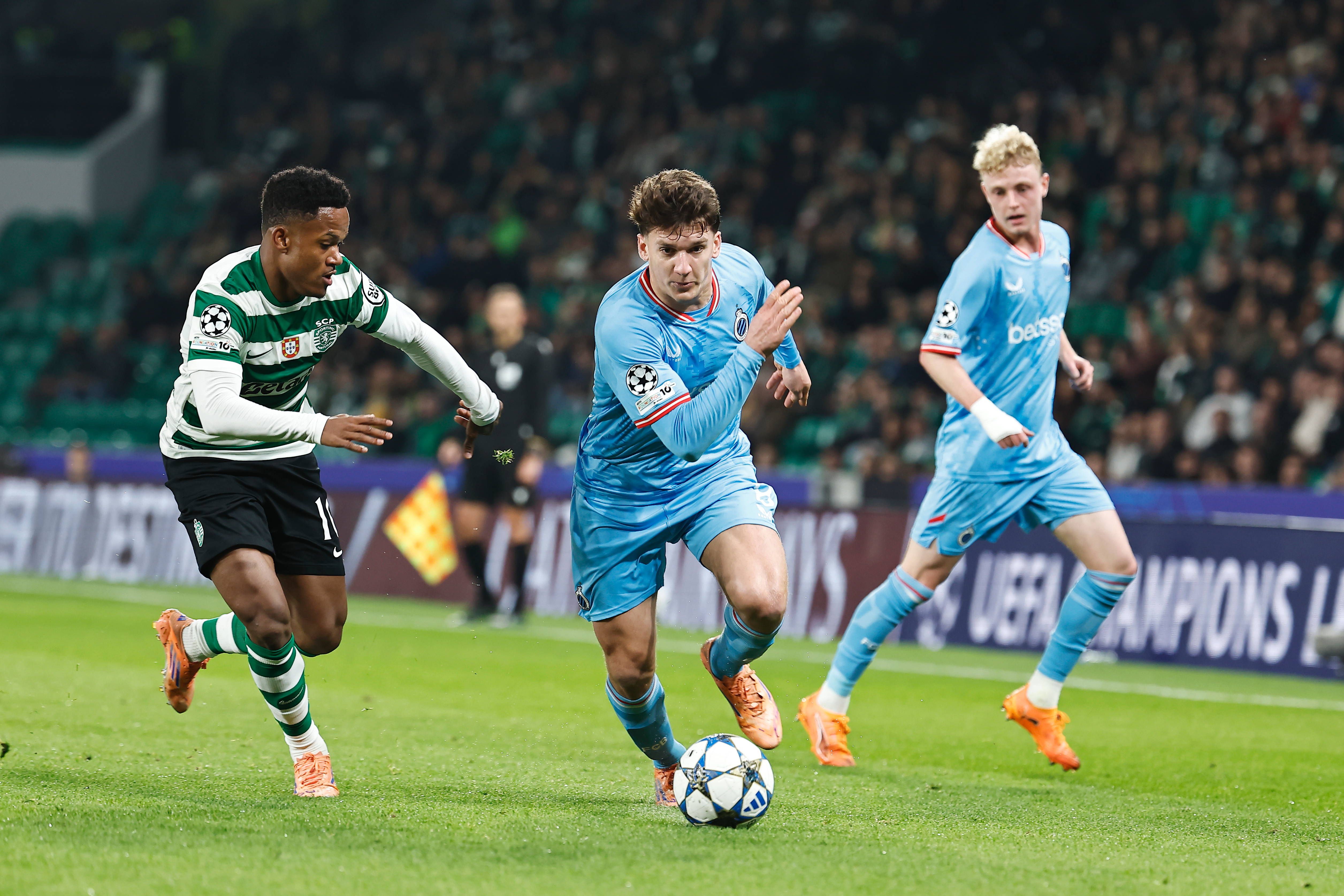 Christos Tzolis, extremo grego de 23 anos do Club Brugge, tenta escapar a Geny Catamo no jogo da 5.ª jornada da Champions - Foto - SPORTING CP