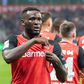 Victor Boniface celebra golo pelo Bayer Leverkusen ao apontar para os símbolo na camisola