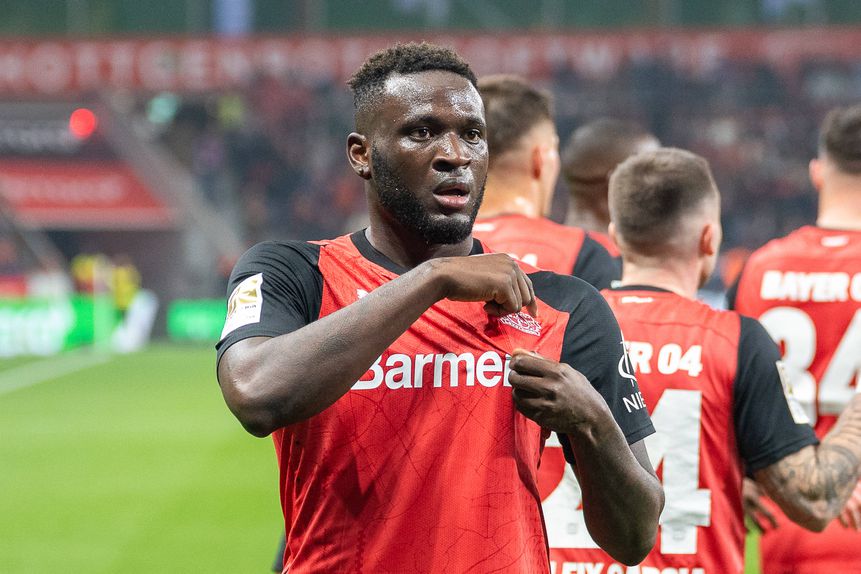 Victor Boniface celebra golo pelo Bayer Leverkusen ao apontar para os símbolo na camisola