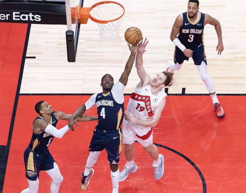 Javonte Green, dos New Orleans Pelicans, luta pelo ressalto com Jakob Poeltl, dos Toronto Raptors, durante o jogo entre as duas equipas