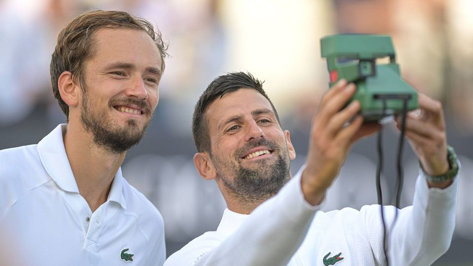 Medvedev ao lado de Djokovic, que está a tirar uma fotografia