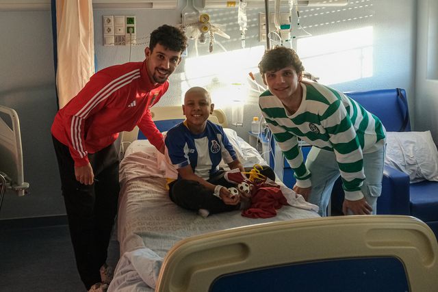 Tomás Araújo (Benfica) e Eduardo Quaresma (Sporting) com uma criança do IPO vestida com a camisola do FC Porto (foto: Liga Portugal)
