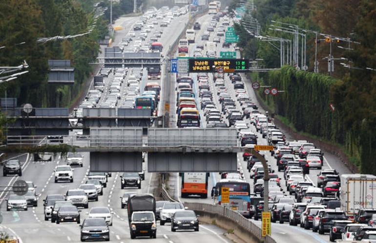 Vehicles crawl along the northbound lane, pictured left, and southbound lane of the Gyeongbu Expressway near Jamwon Interchange in Seocho District, southern Seoul, on Oct. 7.