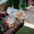 A street vendor counts Ghanaian cedi currency banknotes.Photographer: Ernest Ankomah/Bloomberg