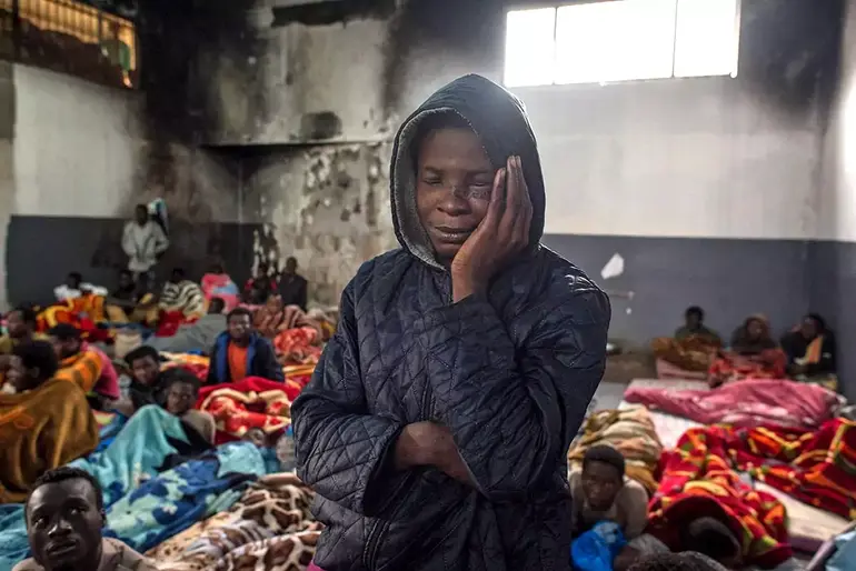 A migrant pictured in a crowded room at the Tariq Al-Matar detention centre on the outskirts of the Libyan capital Tripoli on November 27, 2017 - a often obligatory passage on the route of human trafficking networks to Europe. Photo: © Taha Jawashi / AFP