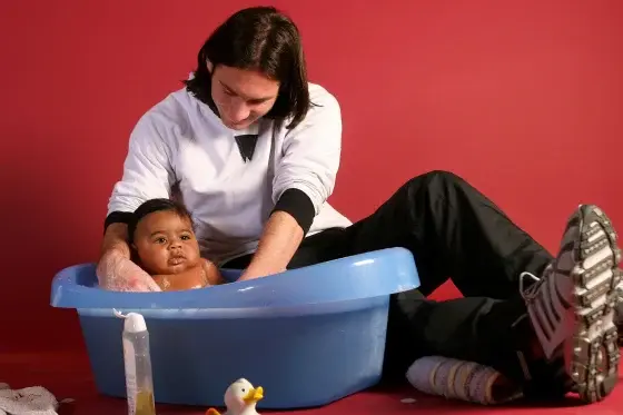 A 20-year-old Lionel Messi helps to bathe Lamine Yamal, who was merely 6 months old at the time, during a photo session in 2007 in the dressing room of the Camp Nou stadium in Barcelona, Spain.Joan Monfort / AP file