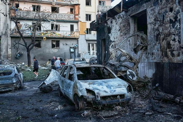 Local residents wander among debris Sunday following a Russian missile attack in Kyiv, Ukraine. Efrem Lukatsky/AP