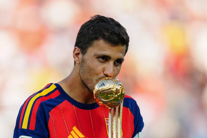 Spain s Rodri kisses the trophy on the podium after winning the Golden Ball following the final match between Spain and Argentina at the 2026 FIFA World Cup.