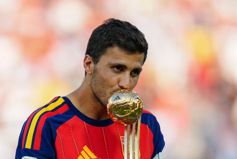Spain s Rodri kisses the trophy on the podium after winning the Golden Ball following the final match between Spain and Argentina at the 2026 FIFA World Cup.