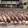 Inmates are lined up during a security operation under the watch of police at Izalco prison in San Salvador, El Salvador, on April 25, 2020. © 2020 El Salvador presidential press office via AP