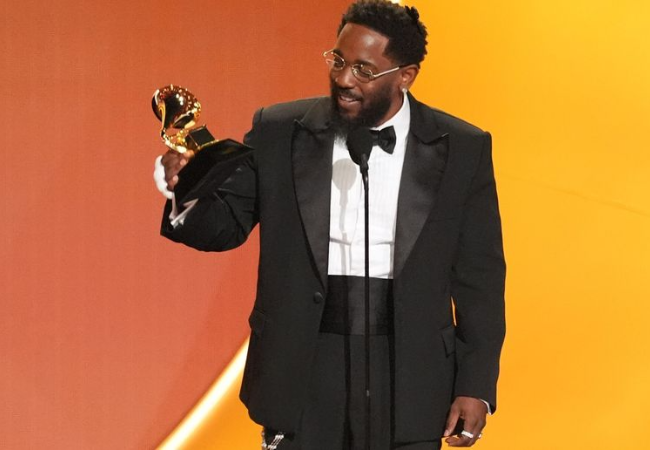 Kendrick Lamar holding his Grammy award for Record of the Year