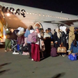 Repatriated Nigerian migrants queueing at night on the tarmac next to a Buraq Air plane at Lagos airport.