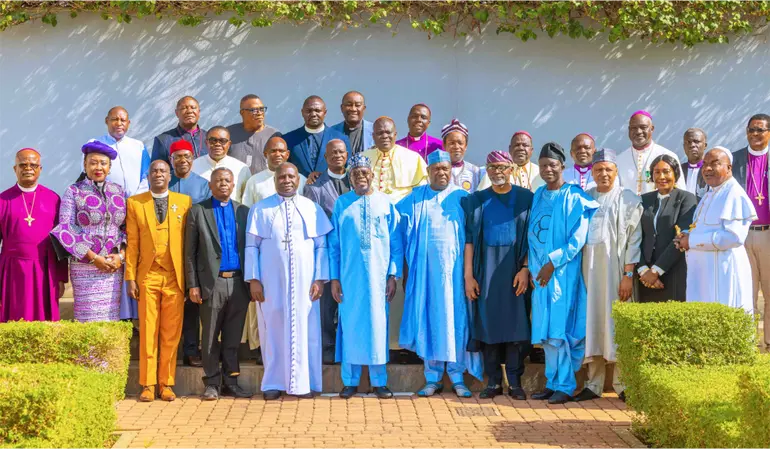 Nigerian President Bola Tinubu standing outdoors in a group photograph with leadership members of the Christian Association of Nigeria (CAN) in traditional and clerical vestments.