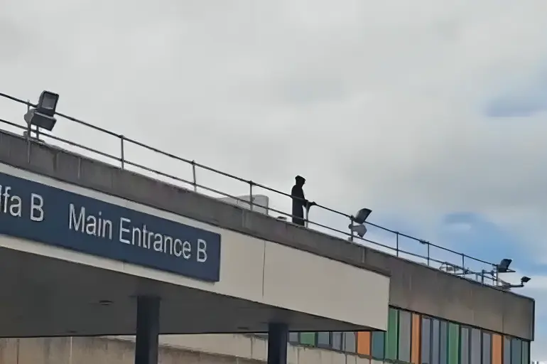 Leon Gillespie scaled Ysbyty Glan Clwyd hospital's roof dressed in a black hooded outfit resembling the "Angel of Death".