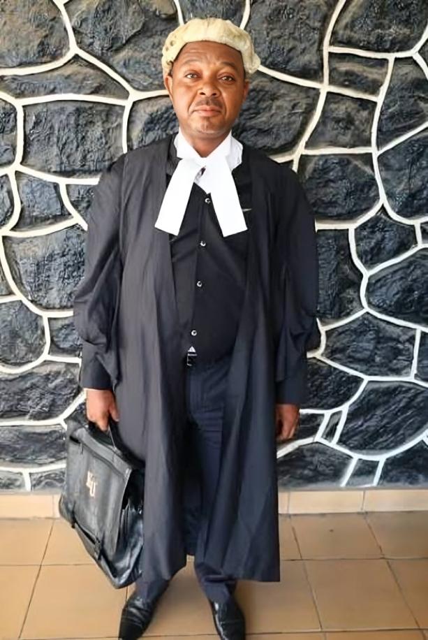Full-length photo of fake lawyer John Nwawuto Anoruo wearing legal gown, wig, and carrying a black briefcase.
