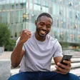 Young Nigerian smiling while using cheap MTN, Glo, and Airtel data on a smartphone
