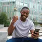 Young Nigerian smiling while using cheap MTN, Glo, and Airtel data on a smartphone
