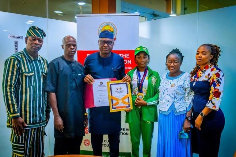 Governor Biodun Oyebanji holding award certificates alongside World Spelling Bee champion Damilola Adeolu, her parents, coach, and school proprietor in Ado-Ekiti.